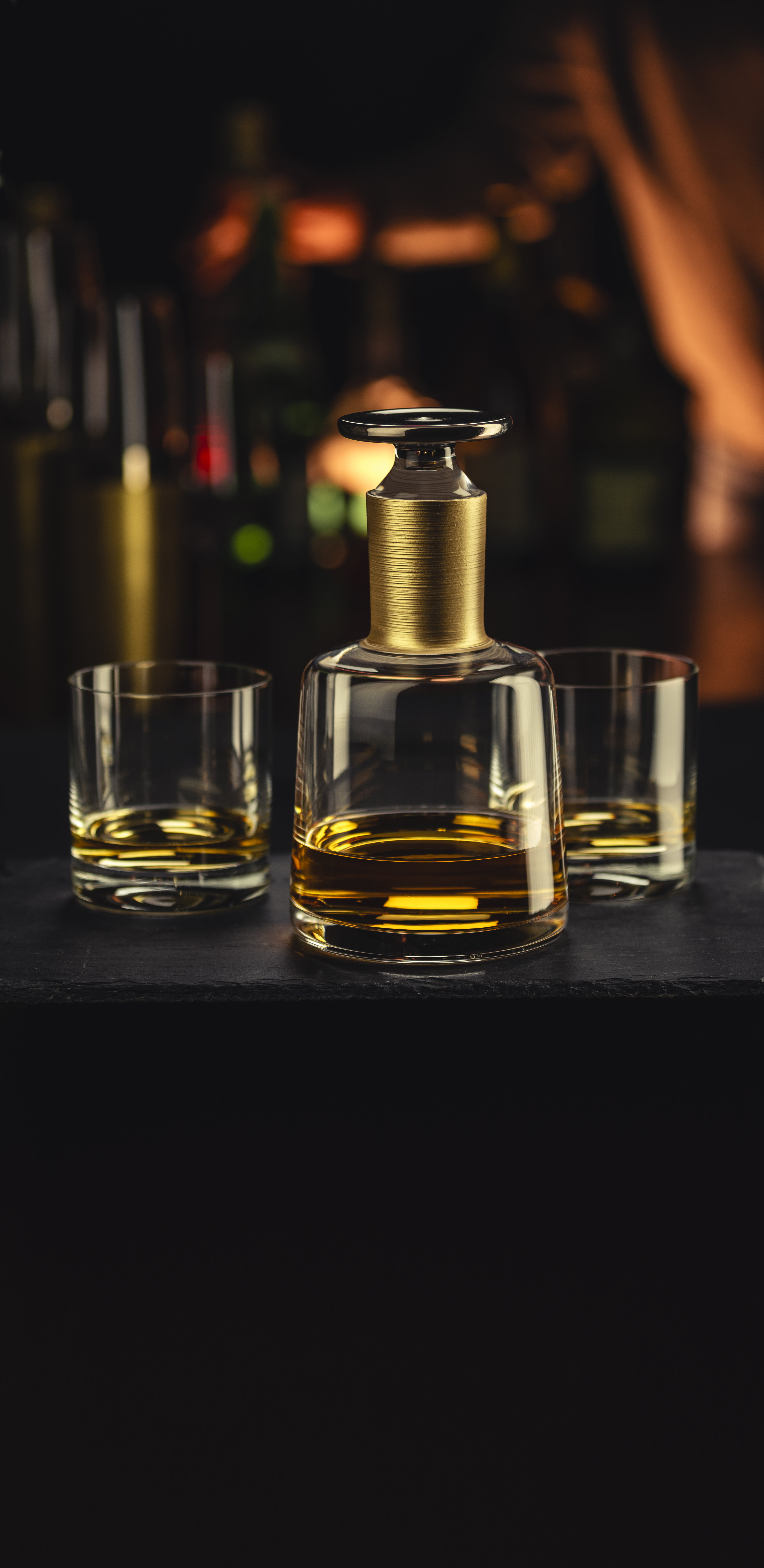 Dark bar scene with whisky decanter and two glasses