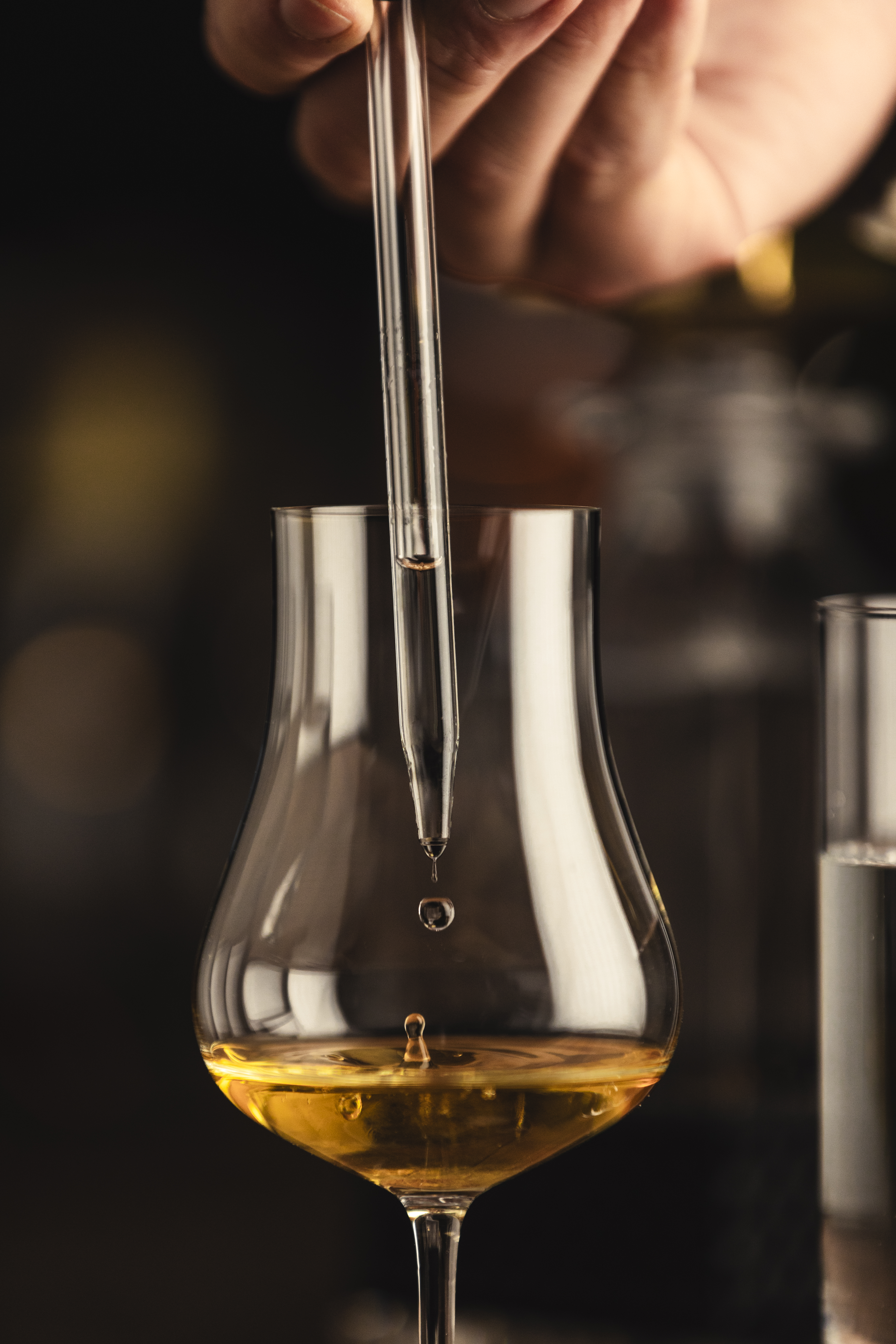 Adding water to a spirit glass using a whisky pipette