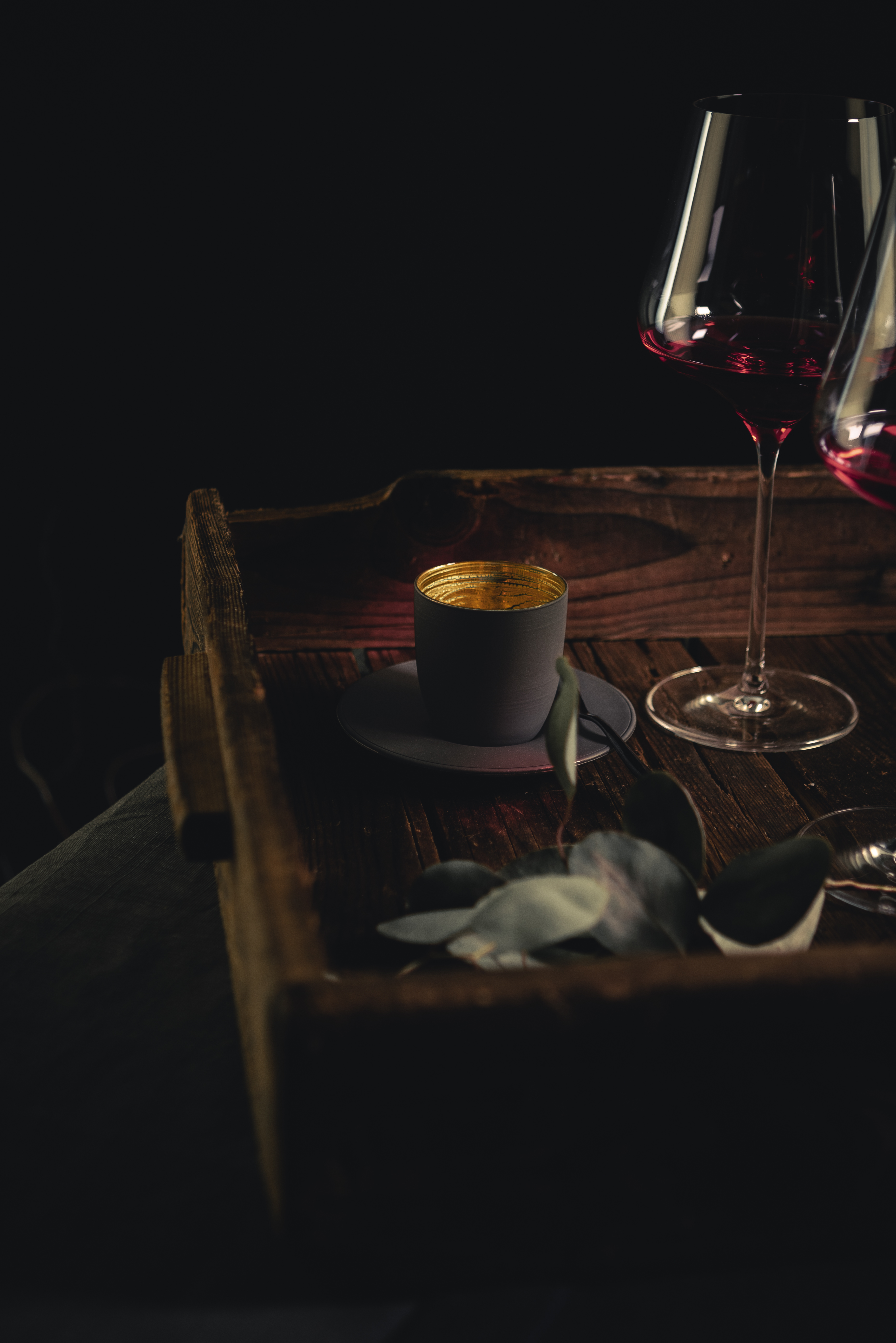 Grey espresso cup with red wine glass on wooden tray